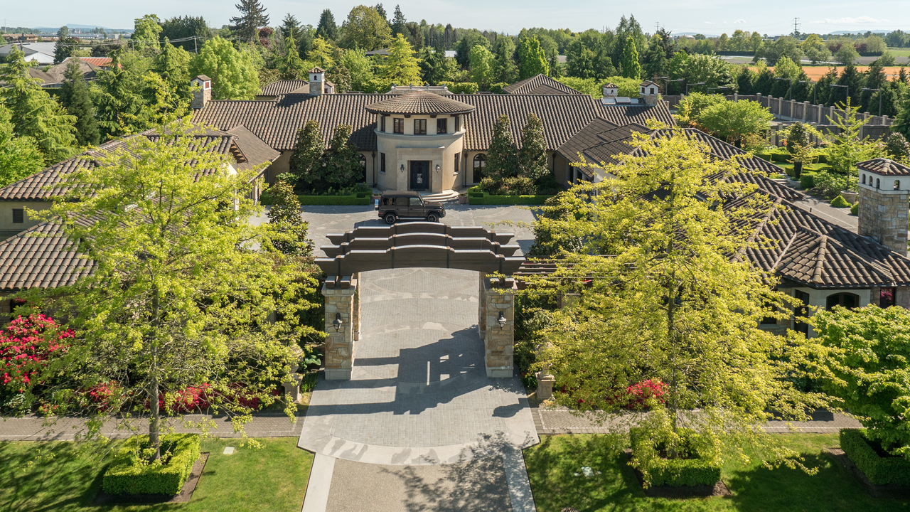 Aerial view of a large, elegant mansion with landscaped gardens and a circular driveway, expertly crafted by a top General Contractor in BC.