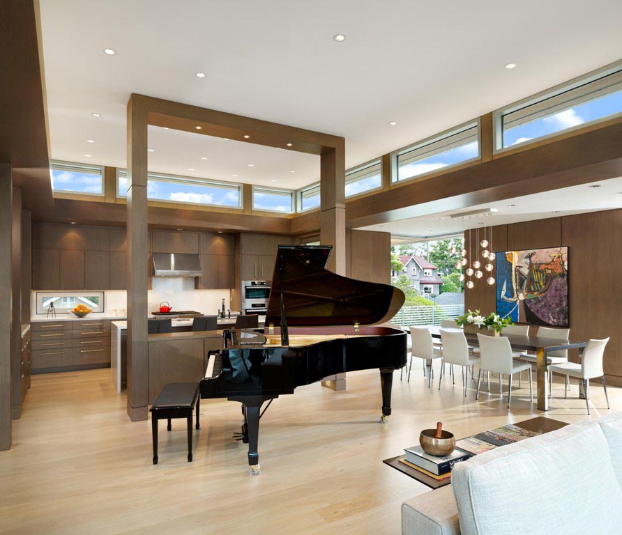 Open-plan living space in Vancouver featuring a grand piano, dining area, and stylish kitchen with large windows—crafted to perfection by a trusted general contractor in BC.